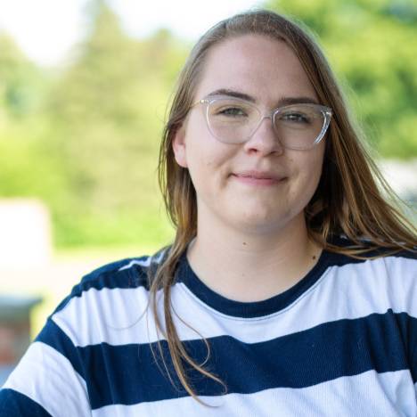 student casually poses for a photo outside